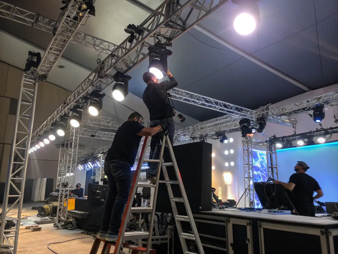 A professional installer meticulously setting up an LED panel display on a stage, ensuring perfect alignment and vibrant color output.